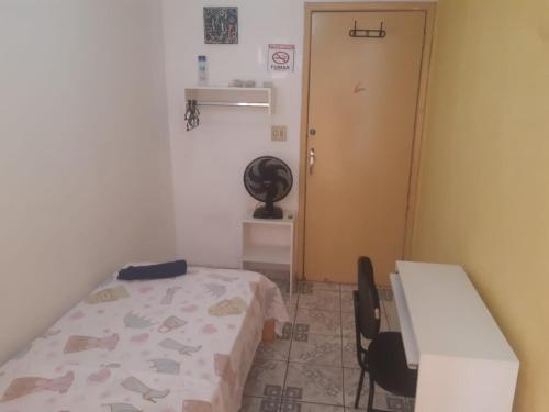 a room with a bed and a desk and a door at Pousada do Luquinhas in Brasilia