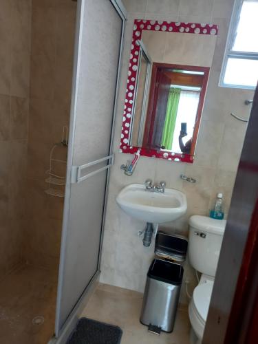 a bathroom with a sink and a toilet and a mirror at CASA cerca a la ESTACIÓN del tren en PAIPA in Paipa
