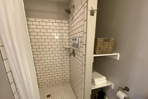 a bathroom with a shower with white subway tiles at Hotel Laurance in Luray