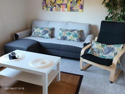a living room with a couch and a table and a chair at Casa Camariñas in Camariñas