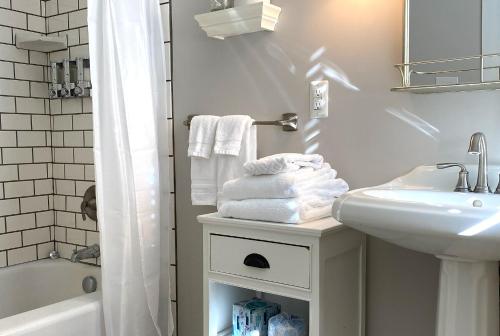 a white bathroom with a sink and a toilet and towels at Hotel Laurance in Luray