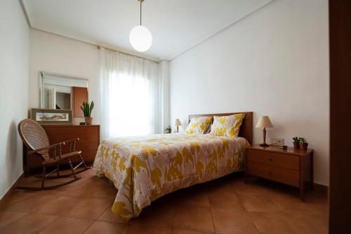 a bedroom with a bed and a chair and a window at La Picaceña in Cuenca