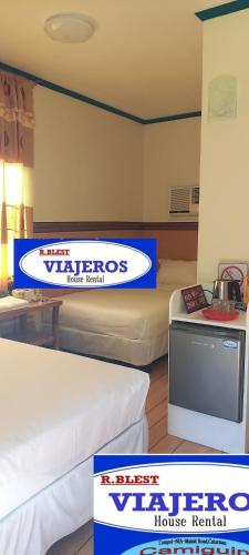 a room with two beds and a tv at Camiguin VIAJEROS House Rental in Compol