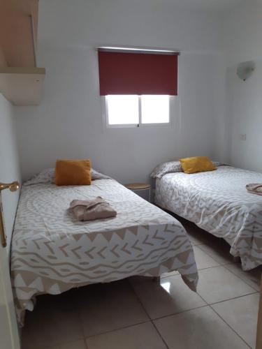 a bedroom with two beds and a window at Apartamento La Aldea Pueblo Gran Canaria 2B in La Aldea de San Nicolas