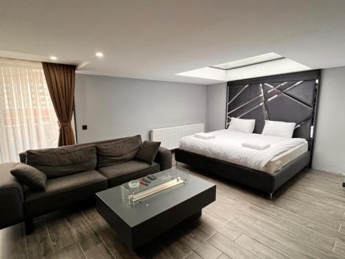 イスタンブールにあるKENT Suites hotels Ataşehirのベッドとソファ付きのホテルルーム