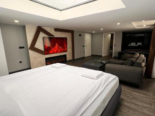 a bedroom with a bed and a living room with a fireplace at KENT Suites hotels Ataşehir in Istanbul
