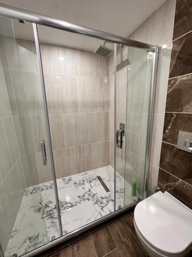 a bathroom with a glass shower with a toilet at Kent Suit Otel in Istanbul