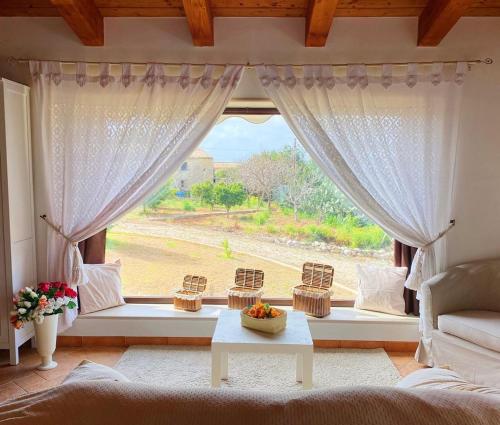 a living room with a large window with a table at Il Rifugio della Quiete in Scicli