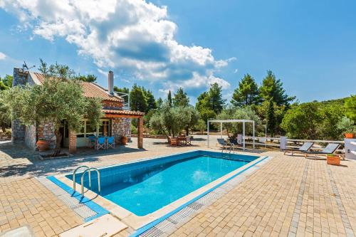 a swimming pool in a yard with a house at Villa Jasmine - Peaceful Sunset View Retreat in Skopelos Town