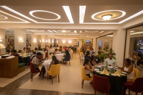 um grupo de pessoas sentadas em mesas em um restaurante em Hacienda Samana Bay Hotel em Santa Bárbara de Samaná