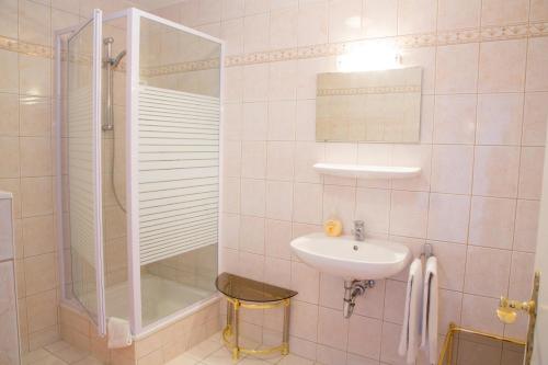 a white bathroom with a sink and a shower at Aparthotel Landau an der Isar in Landau an der Isar