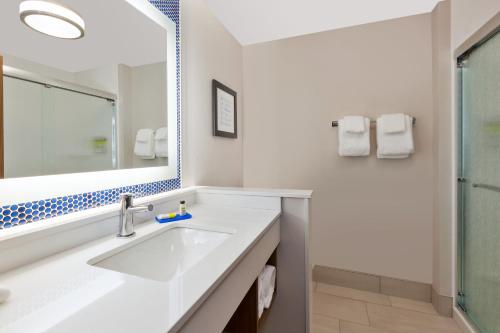 ein weißes Badezimmer mit einem Waschbecken und einem Spiegel in der Unterkunft Holiday Inn Express- Eau Claire West I-94, an IHG Hotel in Eau Claire