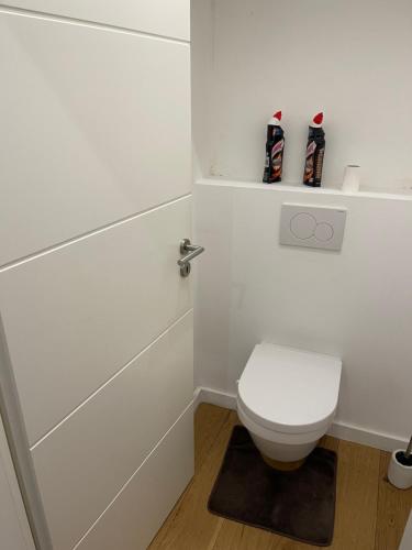 a white bathroom with a toilet and a sink at Superbe appartement au RDC avec parking gratuit in Villerupt