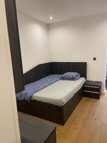 Dormitorio pequeño con cama y espejo en Superbe appartement au RDC avec parking gratuit, en Villerupt