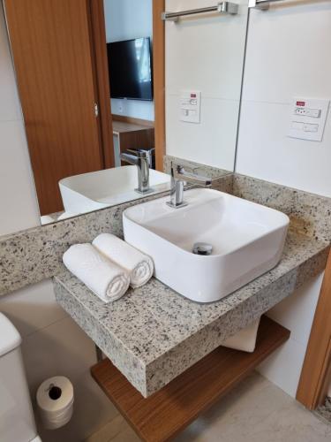 a bathroom with a white sink and a mirror at CONFORTO E EXCLUSIVIDADE in Salinópolis