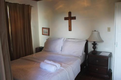 a bed with two towels on it with a cross on the wall at Los Aramos in Valle de Anton