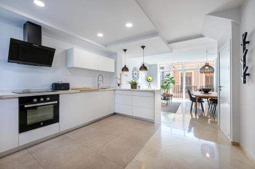 eine Küche mit weißen Schränken und ein Esszimmer in der Unterkunft Precioso apartamento en el centro con aparcamiento in Málaga