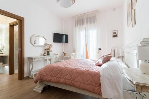 a white bedroom with a pink bed and a desk at My Place In Verona in Verona
