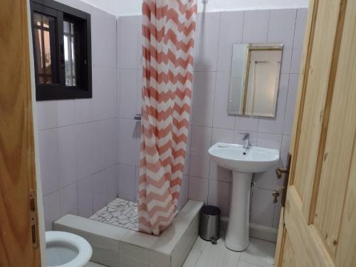 a bathroom with a sink and a shower curtain at Unique Owl Apartments in Sanyang