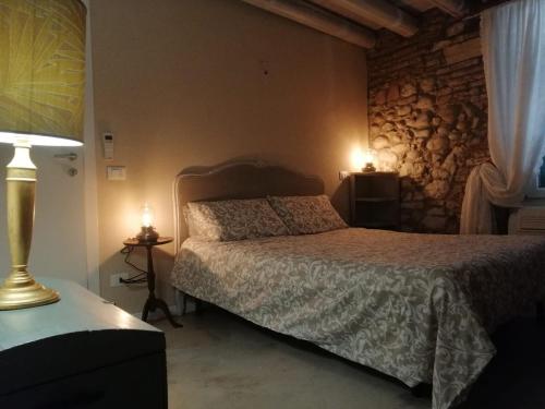 a bedroom with a bed and a stone wall at Saxa Apartment in Verona