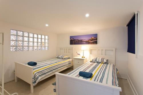2 camas individuales en una habitación con ventana en Oporto Blue Trindade - Magical Citycenter Apartment, en Oporto