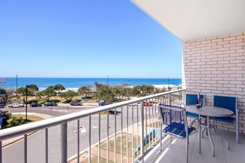 einen Balkon mit einem Tisch und Stühlen sowie Meerblick in der Unterkunft Capeview Apartments - Right on Kings Beach in Caloundra