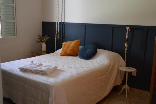 a bed with two towels and two pillows on it at Casa aconchegante em Guapé, Lago de Furnas. in Guapé