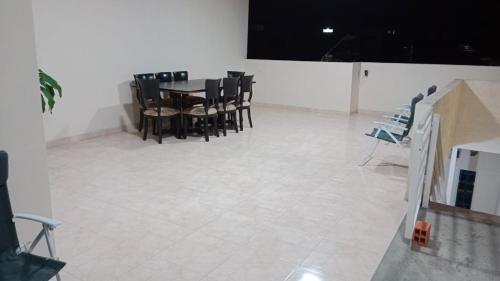 a dining room with a table and black chairs at Hospedaje El Cerrito 2 in El Cerrito