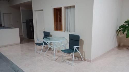 einen Glastisch und Stühle in einem Zimmer in der Unterkunft Hospedaje El Cerrito 2 in El Cerrito