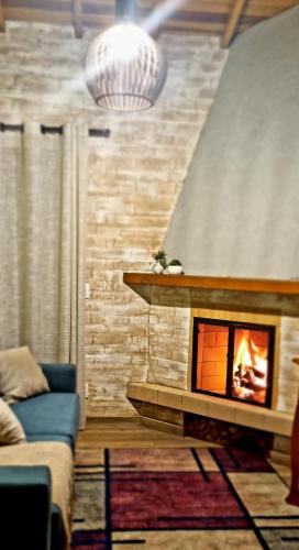 a living room with a fireplace and a couch at Chalés Bella in Monte Verde