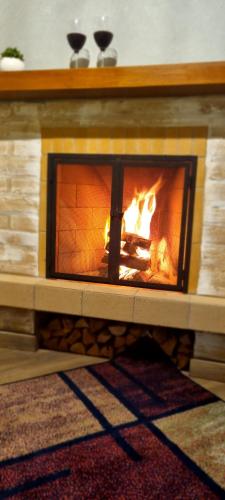 a brick fireplace with a fire in it at Chalés Bella in Monte Verde