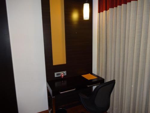 a bathroom with a desk and a chair and a mirror at Astoria Hotels Madurai in Madurai