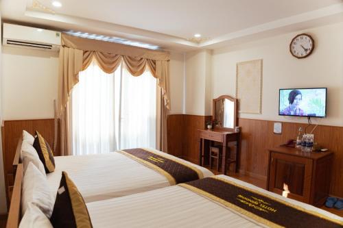 a hotel room with two beds and a television at Window 1 Hotel in Kon Tum