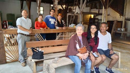 a group of people sitting on a wooden bench at HOSTAL CASA VICTORIA PIJAO in Pijao