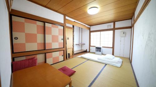 A bed or beds in a room at Kawayu Onsen Guesthouse NOMY