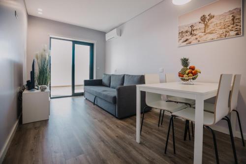 een woonkamer met een tafel en een bank bij Alojamento Amélie - Apartamento in Braga