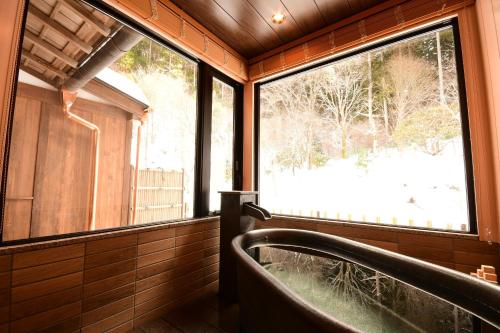 a bathroom with a tub and a large window at 高野山 宿坊 不動院 -Koyasan Shukubo Fudoin- in Koyasan