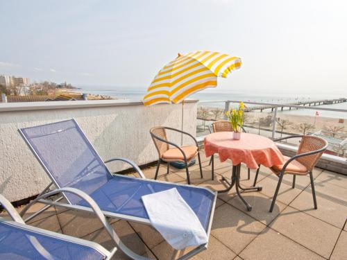 a patio with a table and chairs and an umbrella at Ostsee-Hotel in Großenbrode