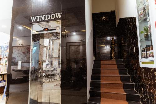a store with a glass door and a stairway at Window 1 Hotel in Kon Tum