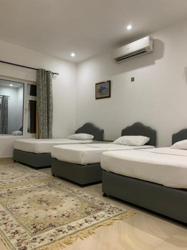 a room with two beds and a mirror at Oriental Nights Rest House in Al Wāşil