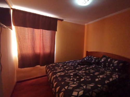 a bedroom with a bed in front of a window at Departamento Vistamar 2 Puertas Pacifico in Arica