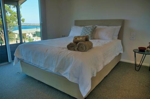 a bedroom with a large bed with towels on it at Emu Bay Bliss 'sweeping ocean views' in Emu Bay