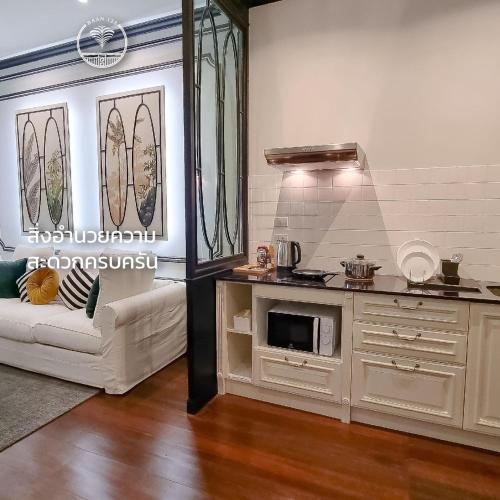 a living room with a couch and a kitchen at BAAN 125 STAY Phuket in Phuket Town
