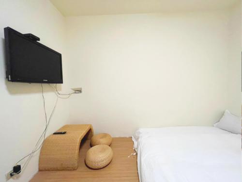 sypialnia z łóżkiem i telewizorem na ścianie w obiekcie 銃樓民宿 Kinmen gunhouse w mieście Jincheng