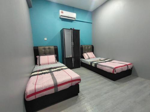 - 2 lits dans une chambre aux murs bleus dans l'établissement Alish Homestay Gua Musang with Free WiFi, Netflix, à Gua Musang