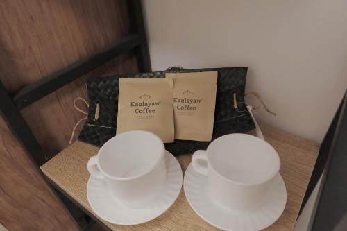 two white tea cups on a table with certificates at AJ Coffee & Bed in Coron
