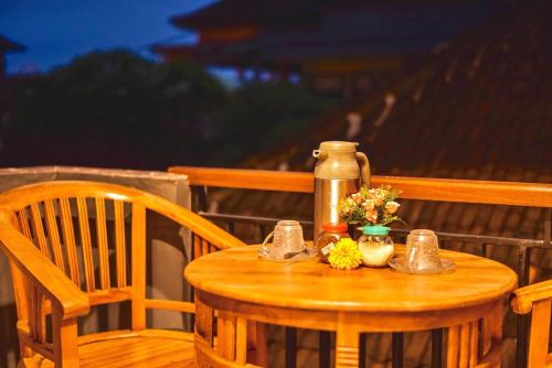 a small wooden table with a thermos and flowers on it at Kamar Suci House in Ubud
