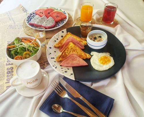a table with a plate of breakfast food on it at Norn Talay Surin Beach Phuket in Surin Beach