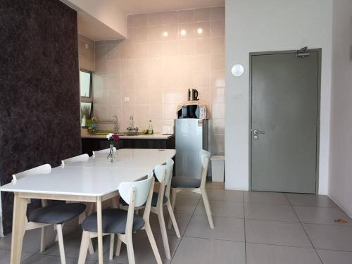 a kitchen with a white table and chairs and a refrigerator at W5WarmStay@Golden Hill/Penthouse/WiFi/3R/NightMarket/2CarPark in Brinchang
