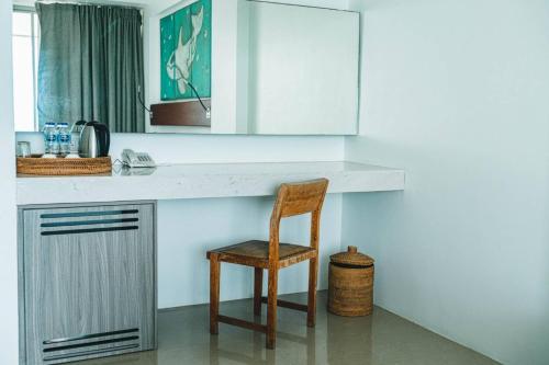 a kitchen with a wooden chair and a counter at Norn Talay Surin Beach Phuket in Surin Beach